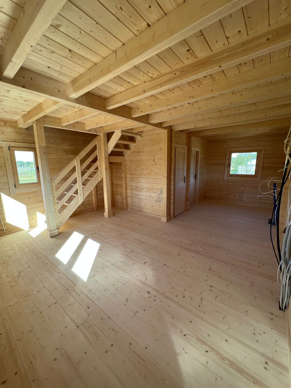 Drewniany budynek z widocznymi drewnianymi belkami i podłogą.
