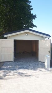 Garaż drewniany z drzwiami otwartymi.