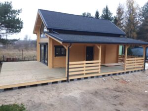 Drewniany domek z zadaszonym tarasem.