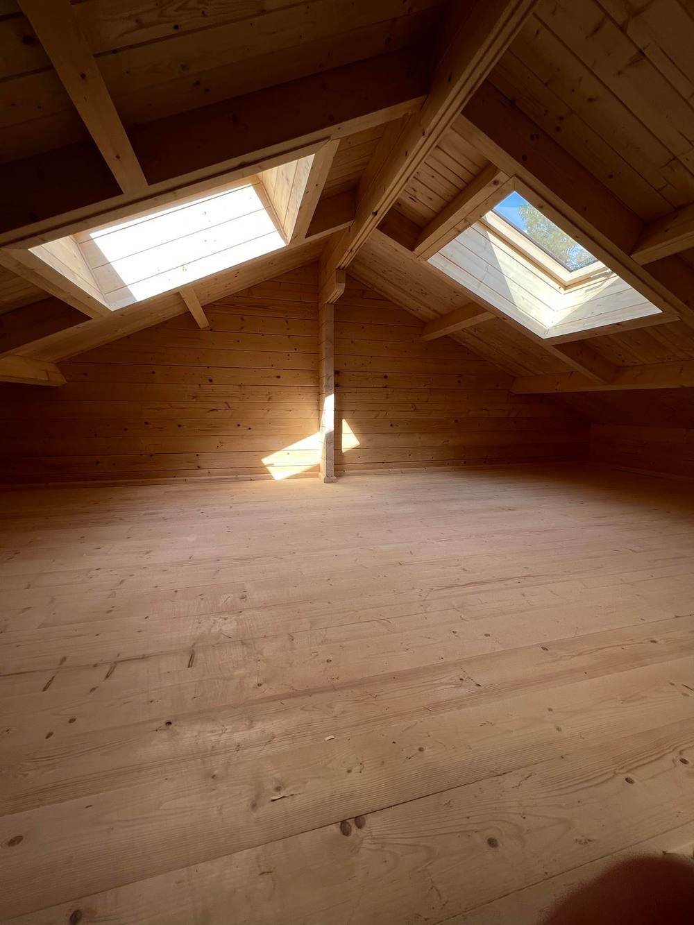 Drewniane wnętrze dachu z oknami dachowymi.