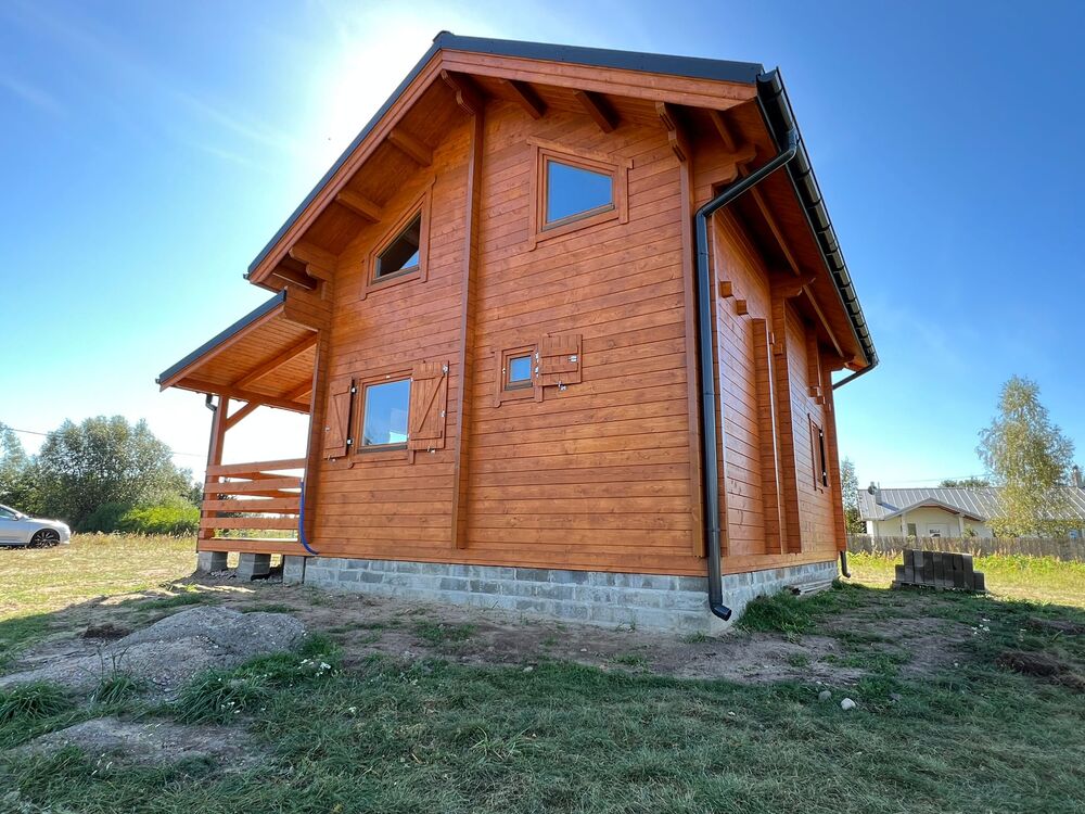 Drewniany dom w wiejskim otoczeniu.