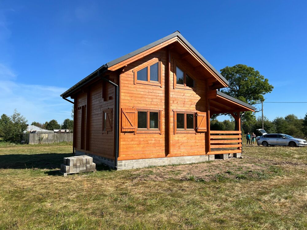 Drewniany dom z dużymi oknami.