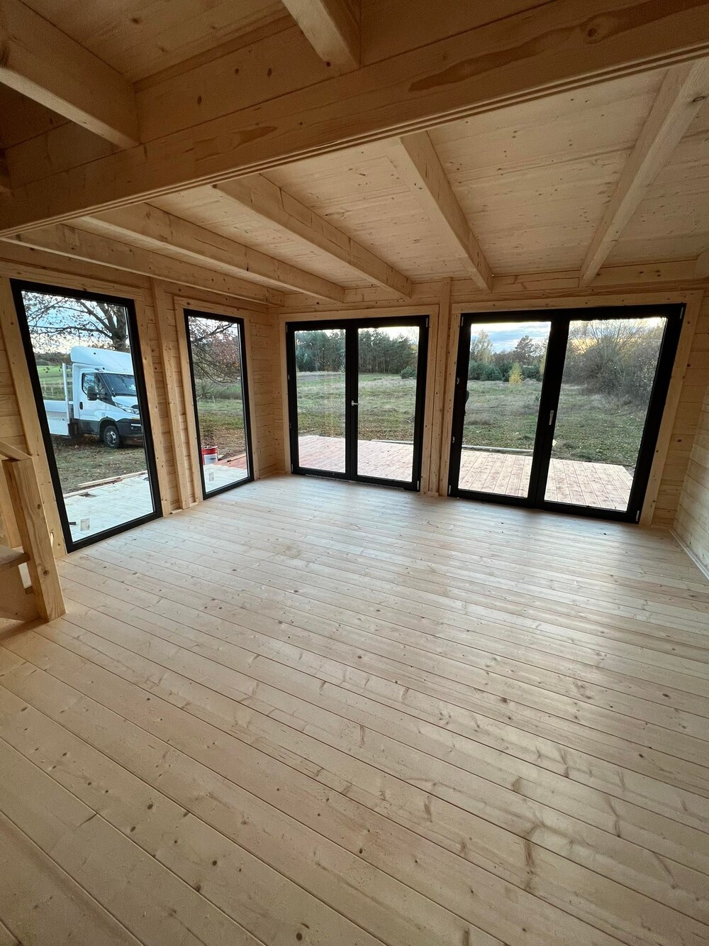 Drewniane wnętrze z dużymi oknami.