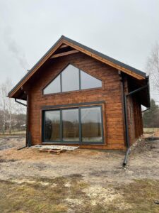 Drewniany dom z dużymi oknami.