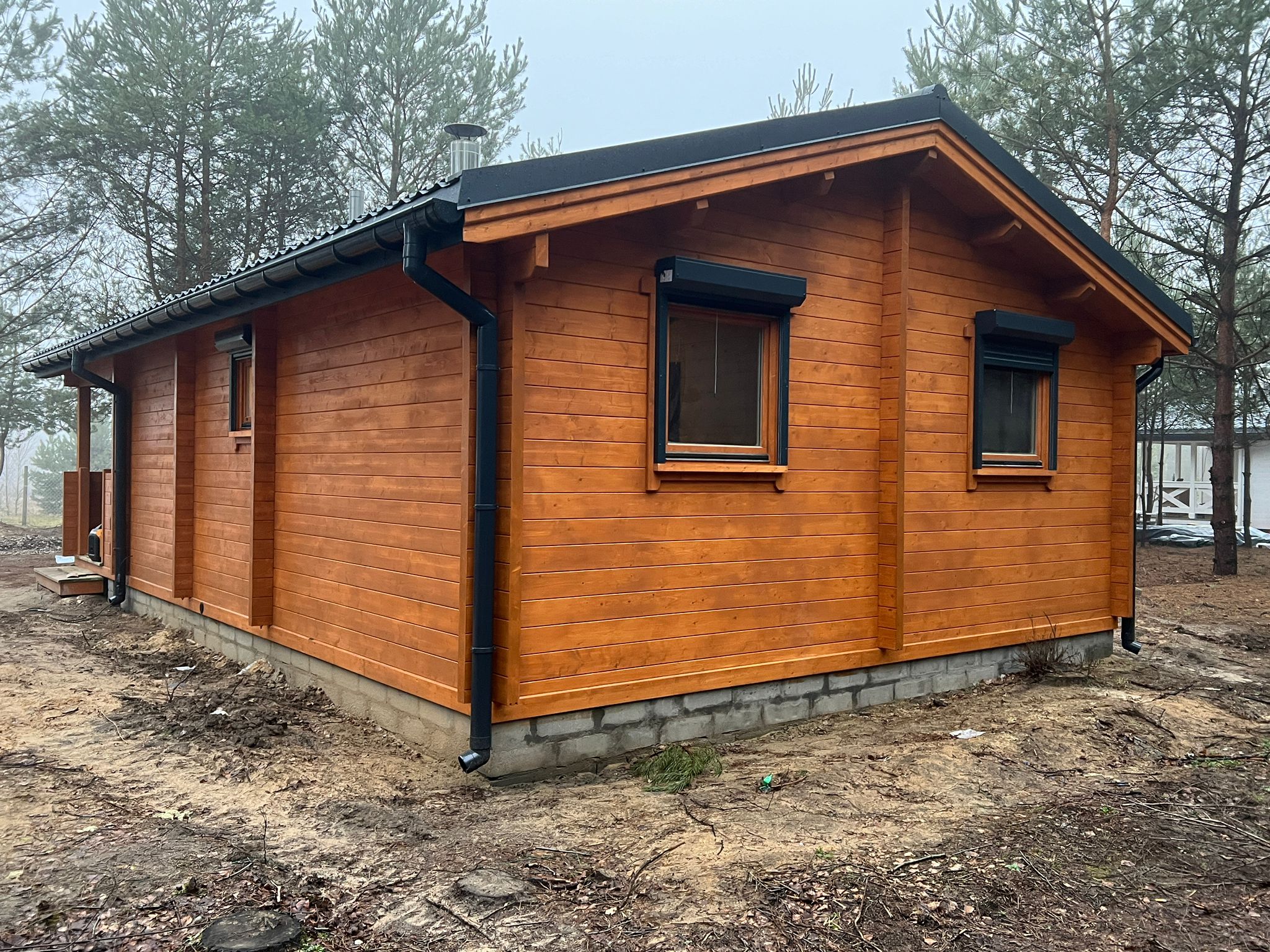 Drewniany dom z czarnym dachem.