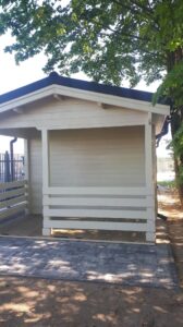 Drewniany domek otoczony drzewami.