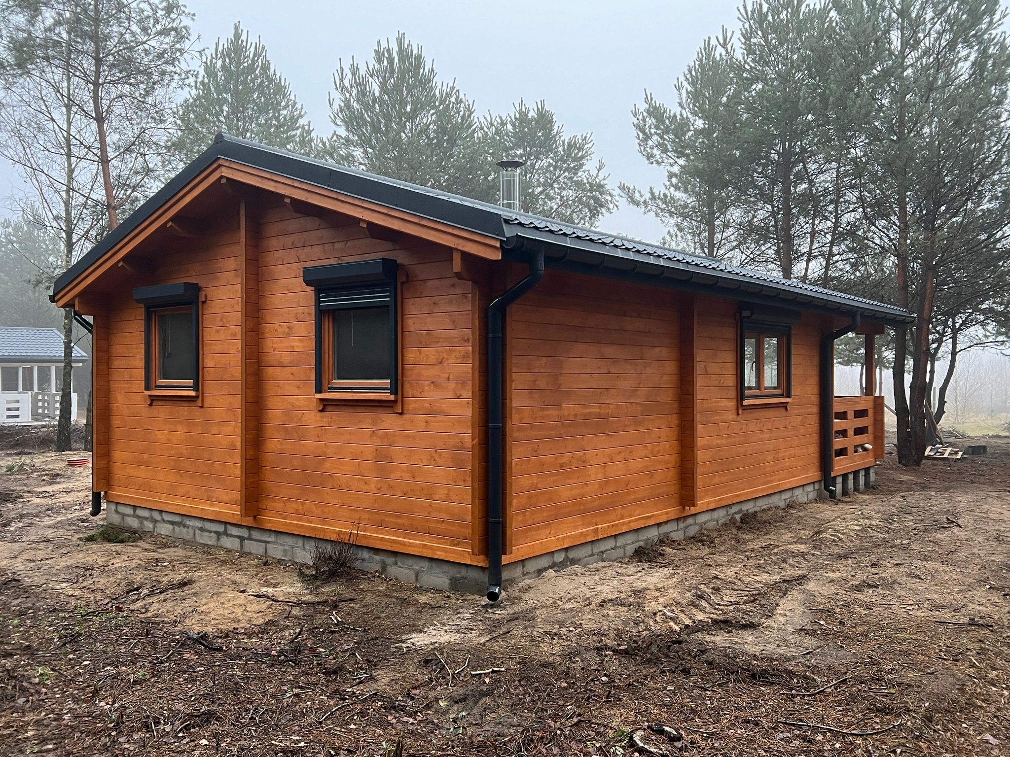 Drewniany dom z czarnym dachem.