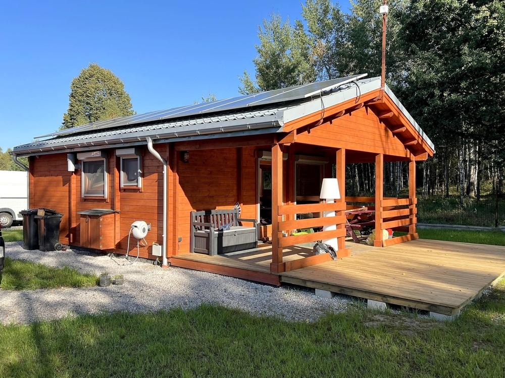 Drewniany domek wypoczynkowy z werandą.