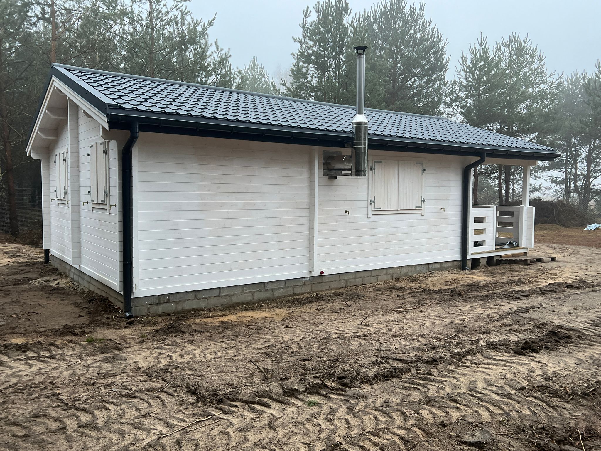 Drewniany dom na tle lasu.