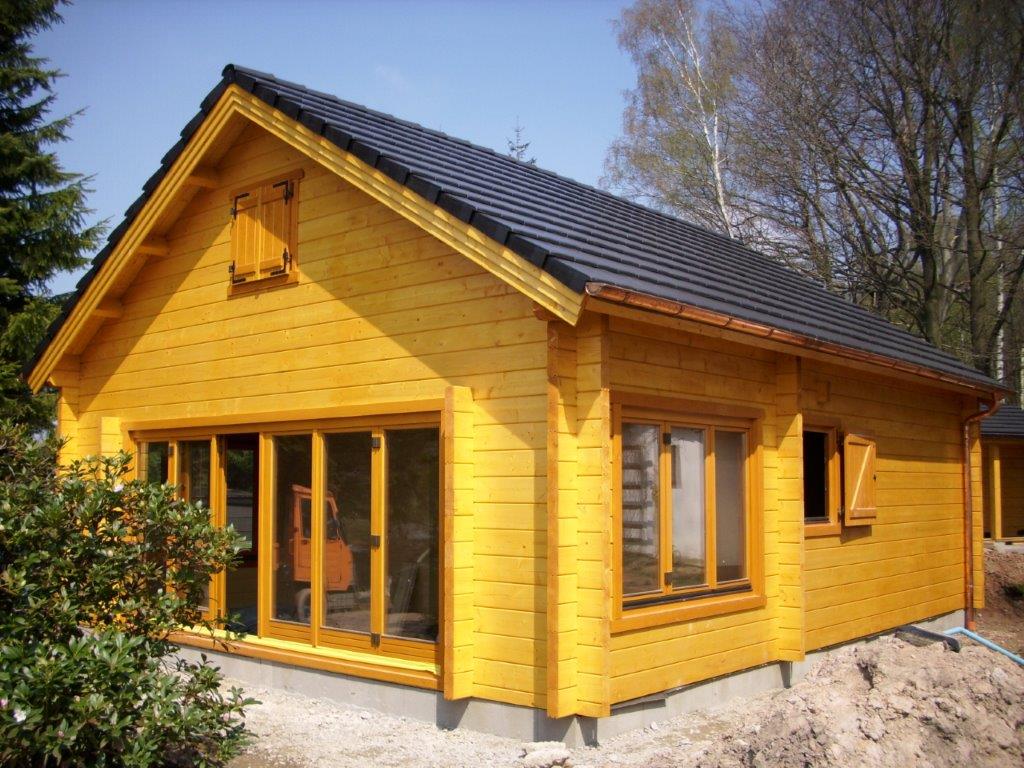 Żółty, drewniany dom na wsi.