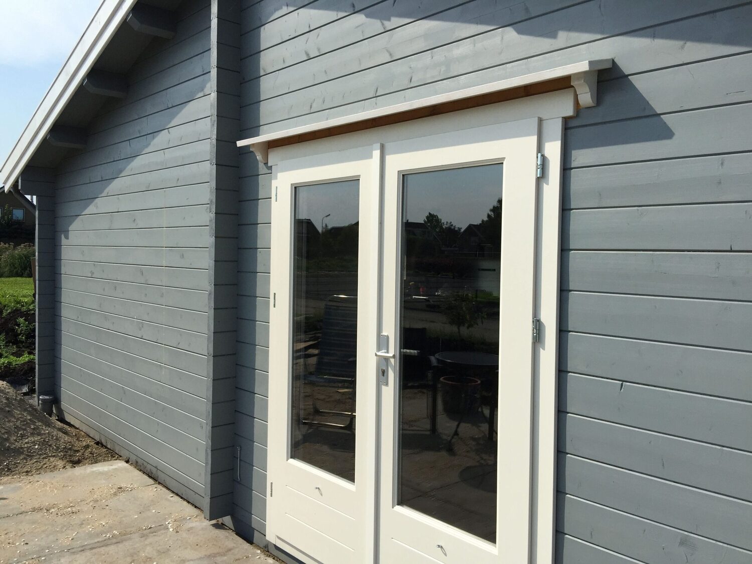 Szare drewniane ściany, białe drzwi.