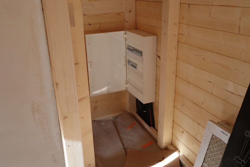 Drewniany domek z białą szafką.