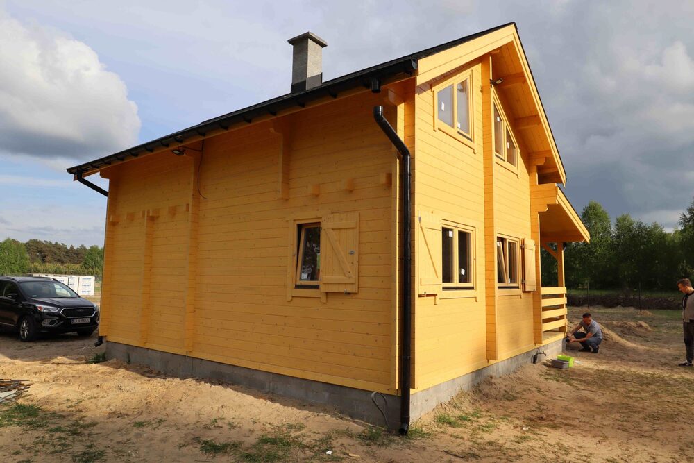 Drewniany dom z żółtymi ścianami.