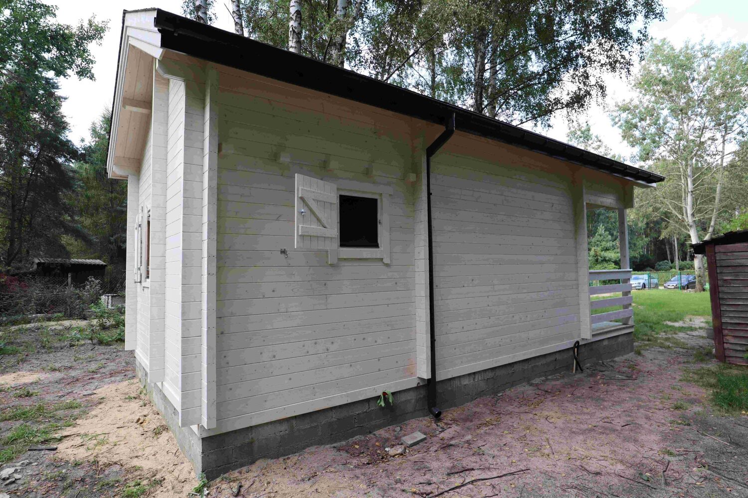 Drewniany dom z zielonym dachem.