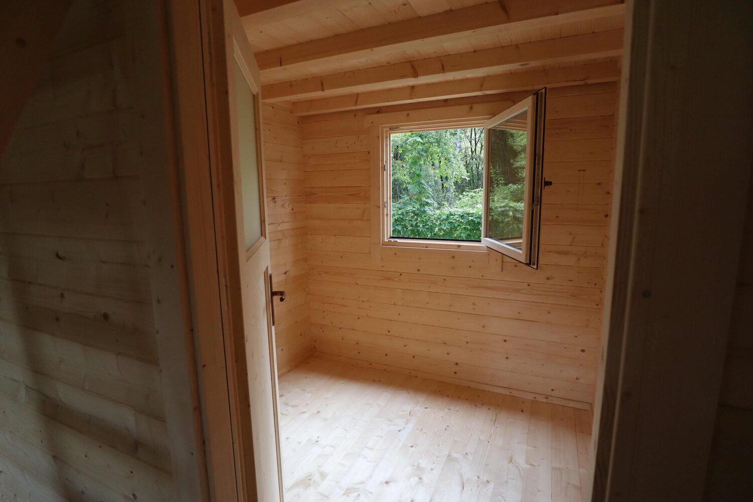 Drewniany pokój z otwartym oknem.