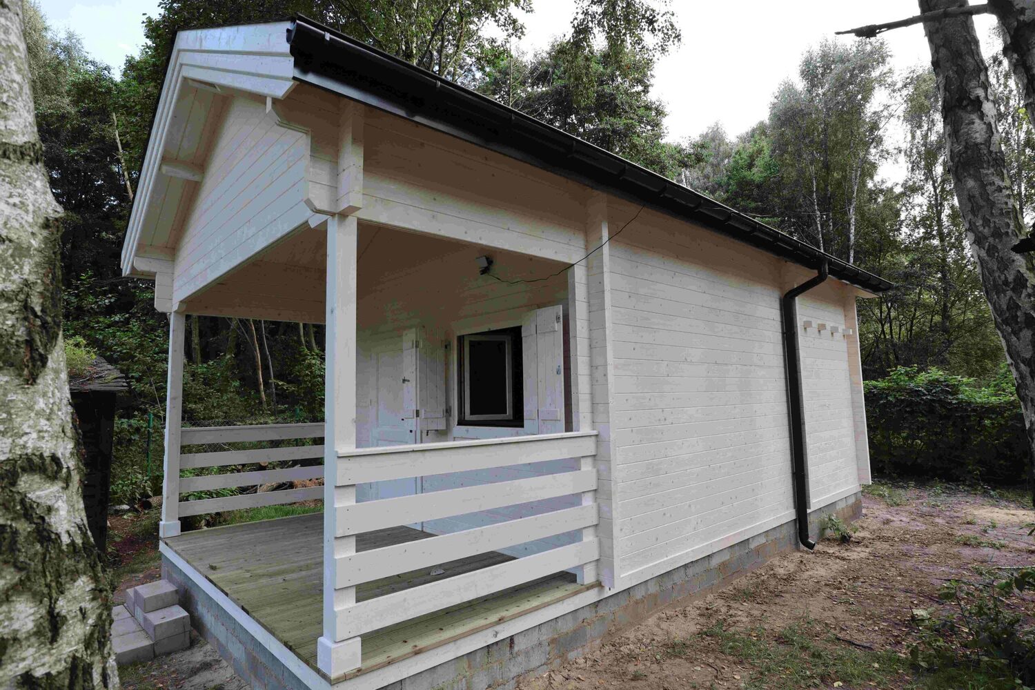 Mały, biały dom na polanie.