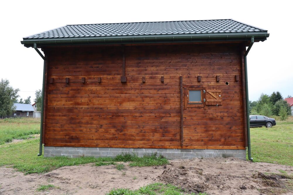 Drewniany budynek z dachówkowym dachem.