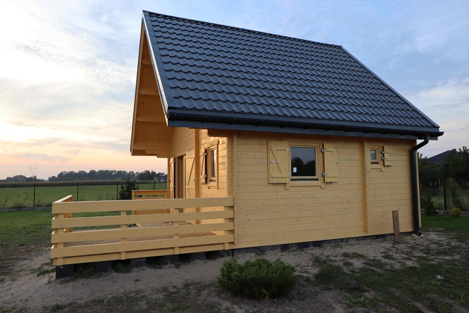 Drewniany dom z czarnym dachem.