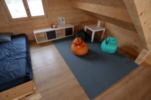 Drewniana chatka, dwa fotele, dywany.