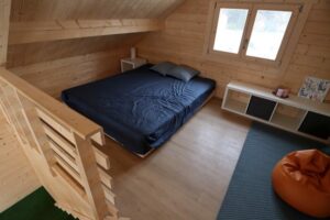 Drewniany domek z łóżkiem.