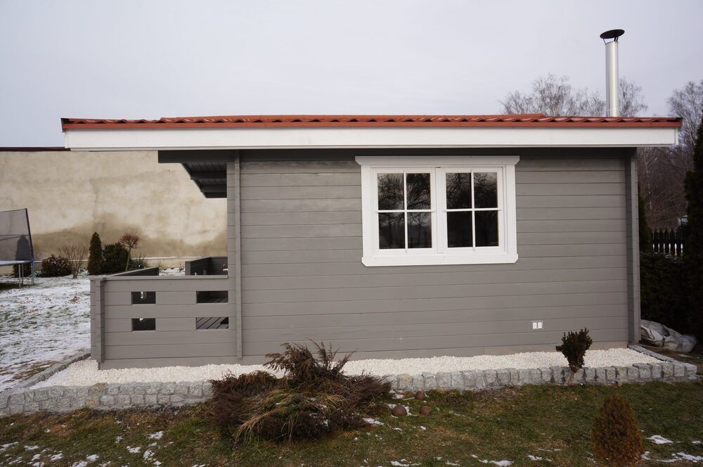 Mały budynek mieszkalny z czerwonym dachem.