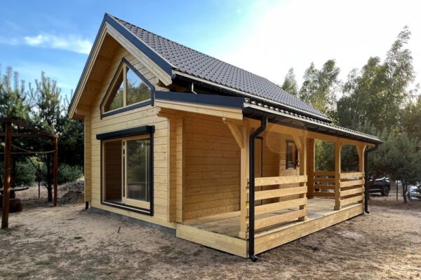 Mały, drewniany dom ze szpiczastym dachem.