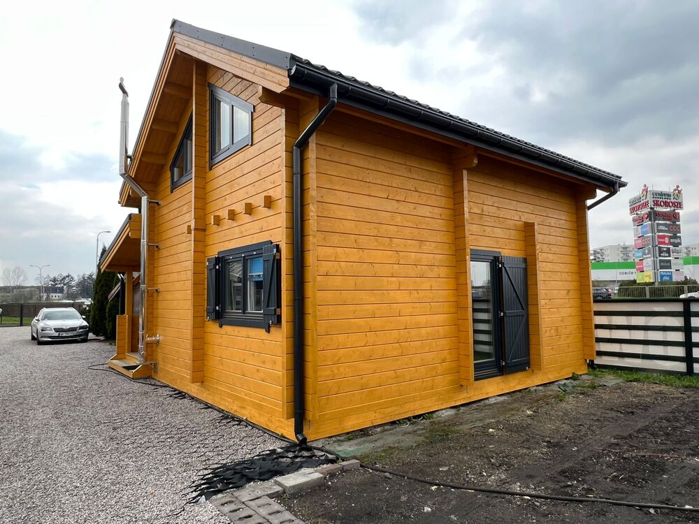 Drewniany dom z czarnymi oknami.