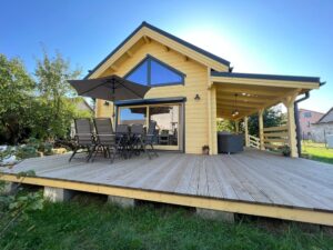 Drewniany dom z werandą, meble ogrodowe.