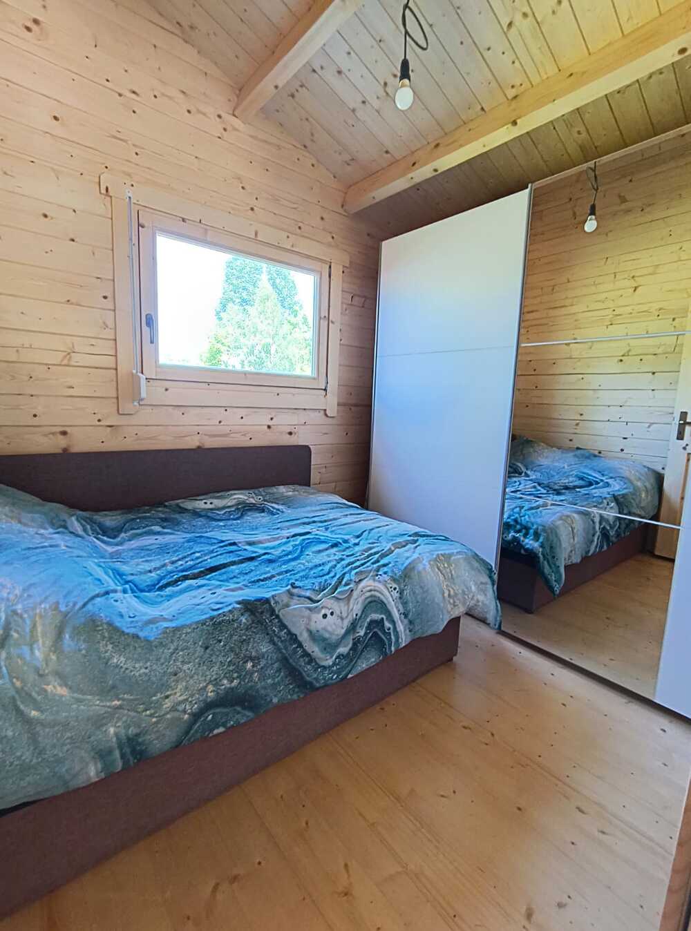 Drewniana sypialnia z łóżkami.