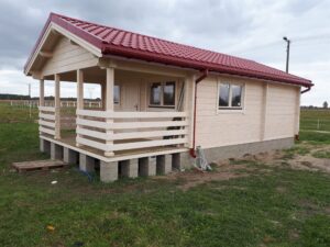 Dom drewniany z czerwonym dachem.