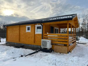 Drewniany domek zimowy w śniegu.