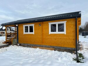 Drewniany dom z ciemnym dachem.