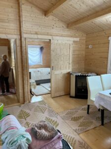 Drewniane wnętrze domku z meblami i dekoracjami.