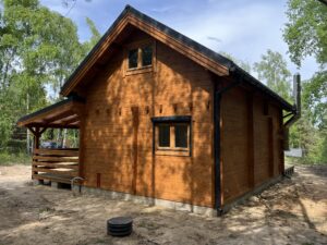 Drewniany dom z bali w lesie.