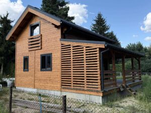 Drewniany domek na wsi z tarasem.