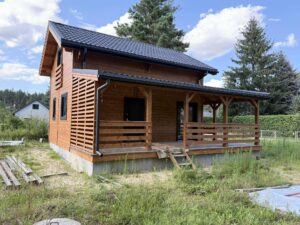 Drewniany dom na wzgórzu z tarasem.