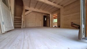 Wnętrze domu z drewnanymi ścianami i podłogą.
