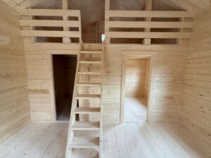 Drewniana chatka z drabinami.