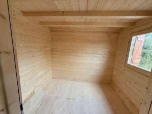 Drewniana chatka z białą wykładziną.