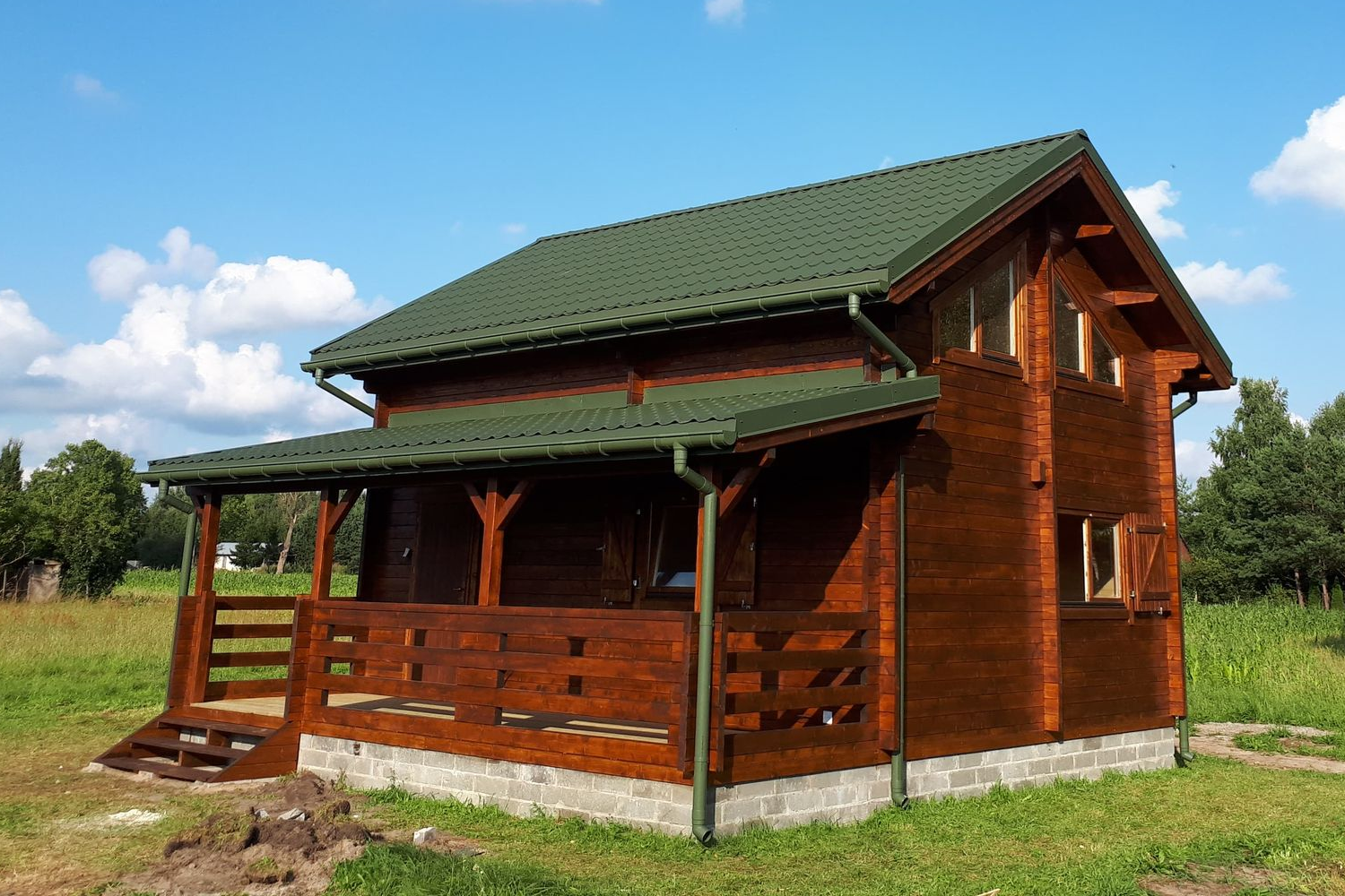 Drewniany dom z zielonym dachem.