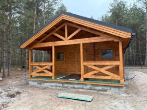 Drewniany dom na tle lasu.