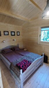 Drewniany pokój z łóżkiem.