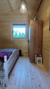 Drewniana sypialnia z oknem.