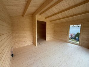 Drewniane wnętrze z dużymi oknami.