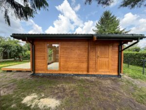 Drewniany domek z tarasem i oknami.