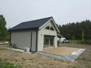 Mały dom drewniany z czarnym dachem.