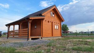 Drewniany dom z czarnym dachem.