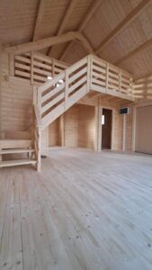 Wnętrze drewnianego budynku z drewnianymi balkonami.