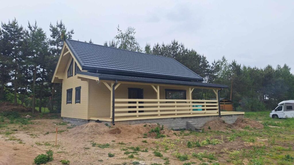 Domek na wsi, drewniany, z werandą.