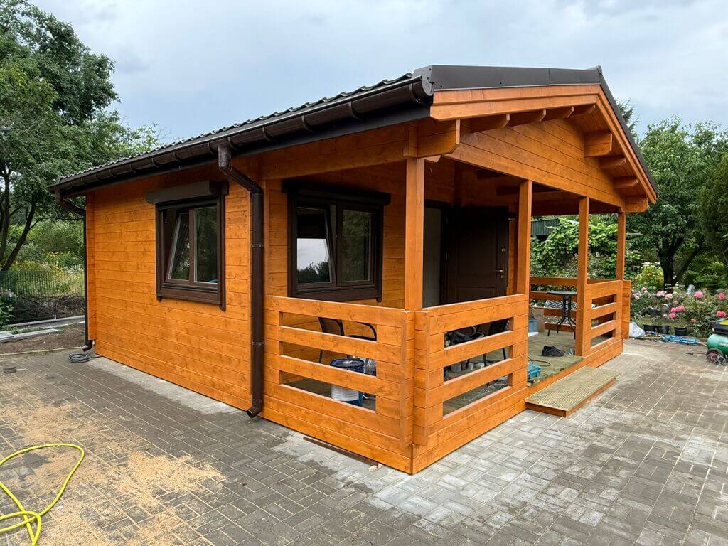 Drewniany domek ogrodowy z zadaszeniem.